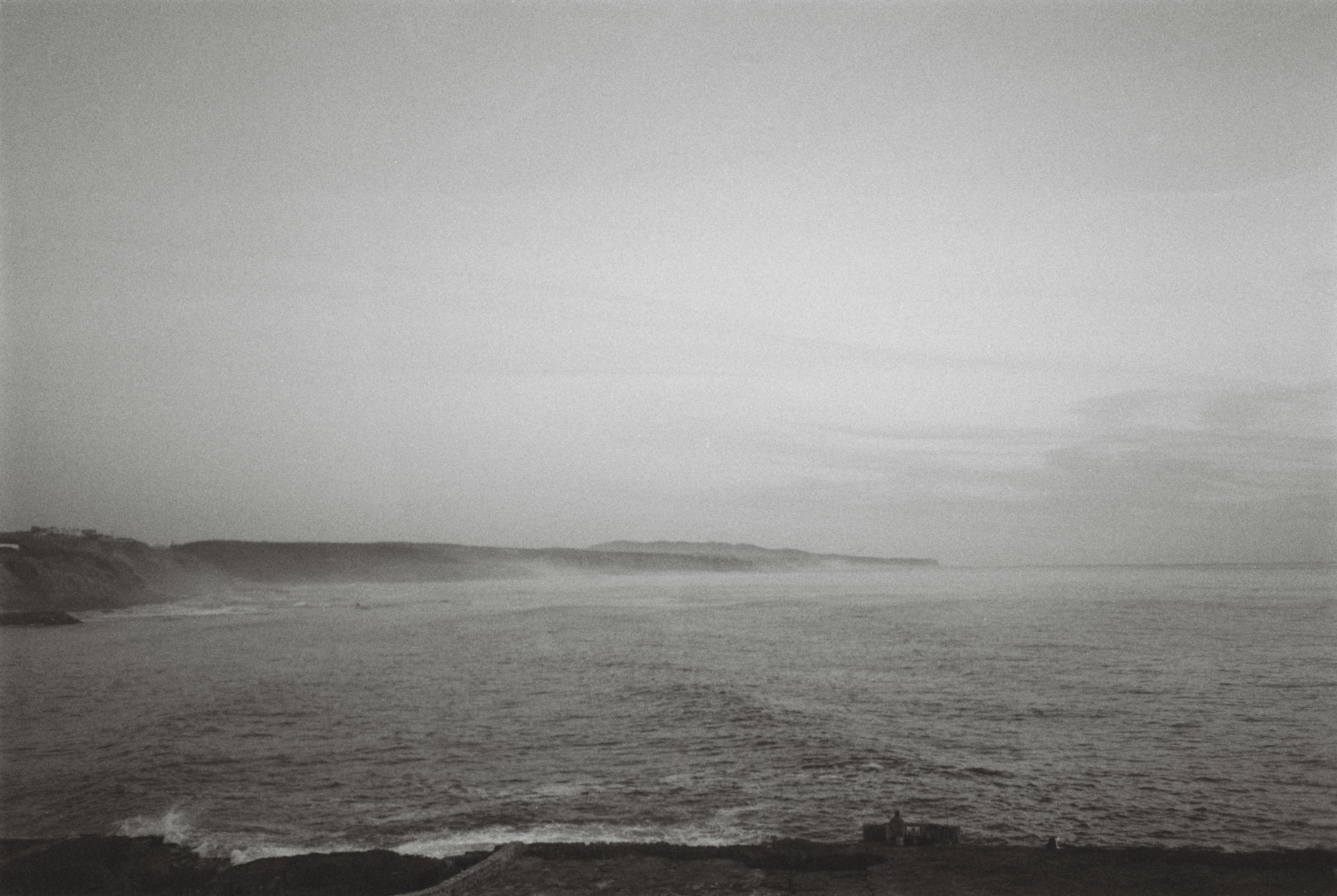 Black and white landscape picture of the sea by the coast of Portugal with calm water